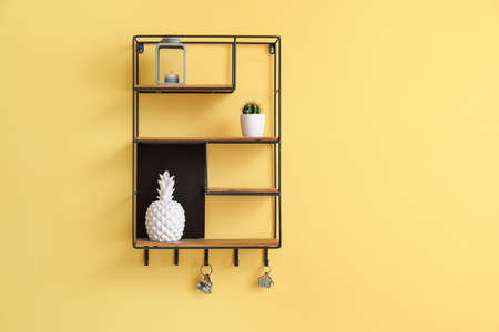 Shelf with decor and keys hanging on color wall