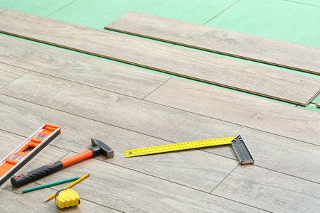New laminate flooring with tools in roomの写真素材