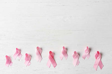 Pink ribbons on light wooden background. Breast cancer concept