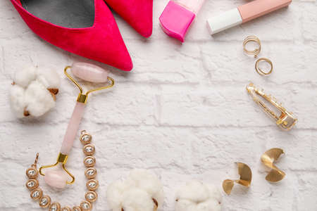 Frame made of female accessories and cotton flowers on light brick backgroundの写真素材