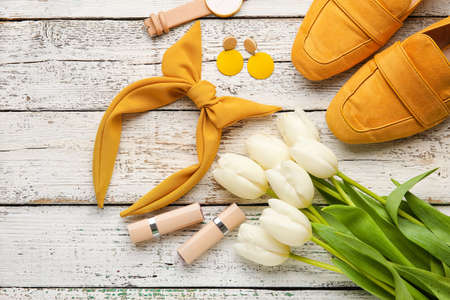 Set of female accessories with flowers on light wooden backgroundの写真素材
