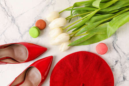 Stylish female shoes, beret and flowers on light backgroundの写真素材