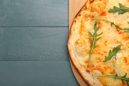Board with tasty cheese pizza on color wooden backgroundの写真素材
