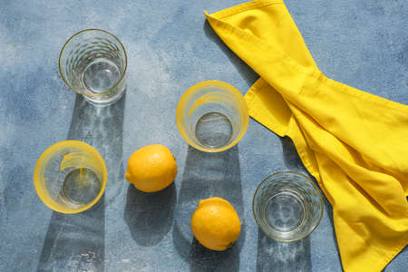 Beautiful empty glasses and lemons on color backgroundの写真素材