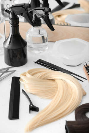 Barber's tools and strand of blonde hair on table in beauty salonの写真素材
