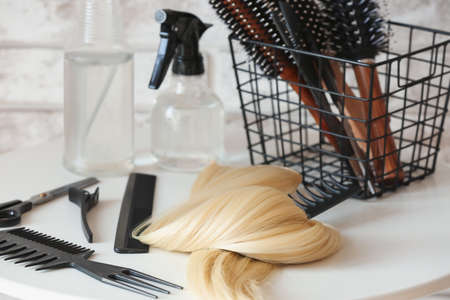 Barber's tools and strand of blonde hair on table in beauty salonの写真素材