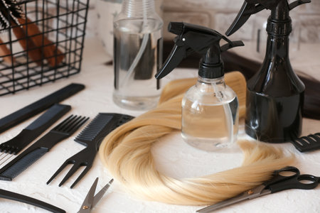 Barber's tools and strand of blonde hair on table in beauty salonの写真素材