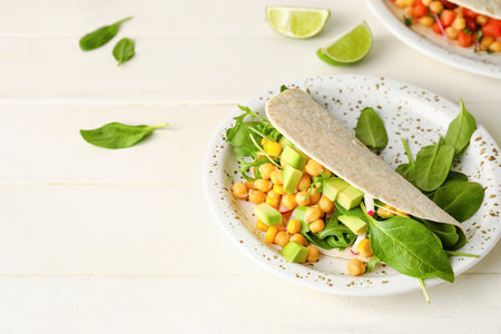 Plate with tasty vegetarian taco on light wooden backgroundの写真素材