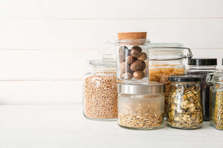 Glass jars with different products on light wooden backgroundの写真素材