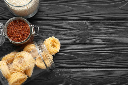 Glass jars with different products on dark wooden backgroundの写真素材