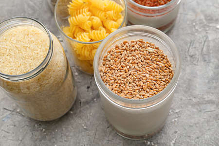 Glass jars with different products on grunge backgroundの写真素材