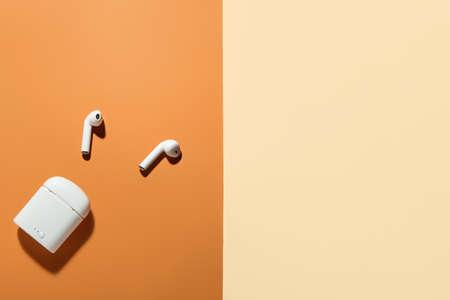 Modern earphones with case on color backgroundの写真素材