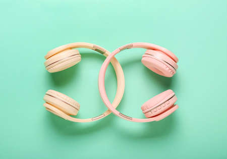 Modern headphones on color background