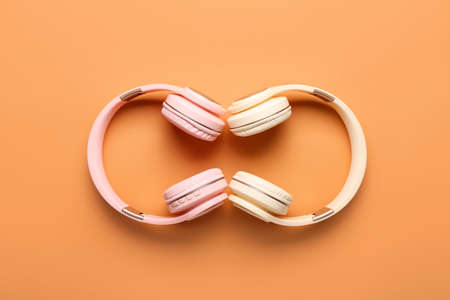 Modern headphones on color background