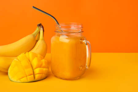 Mason jar of healthy smoothie with fruits on color backgroundの写真素材