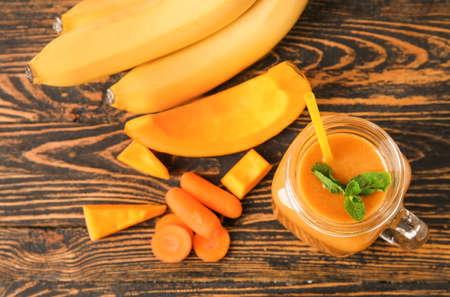 Mason jar of healthy smoothie and ingredients on wooden backgroundの写真素材