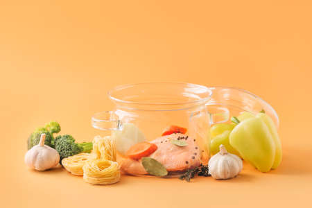 Stylish cooking pot and products on color backgroundの写真素材