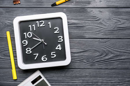 Composition with stylish clock and stationery on dark wooden backgroundの写真素材