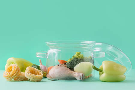 Stylish cooking pot and products on color backgroundの写真素材