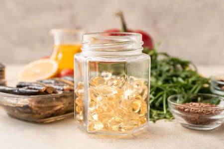 Jar with fish oil pills on light backgroundの写真素材