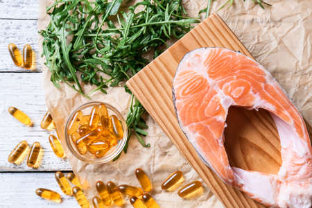Composition with fish oil pills on light wooden backgroundの写真素材