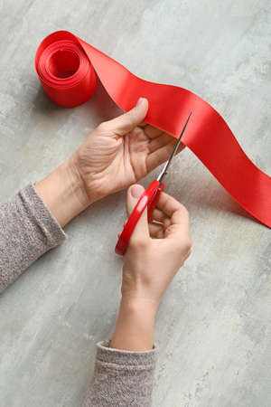 Woman cutting red ribbon on grunge backgroundの写真素材