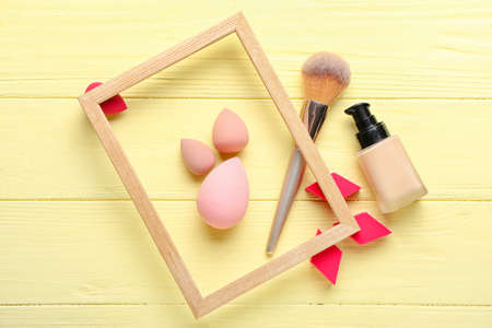 Makeup sponges with brush and foundation on color wooden backgroundの写真素材