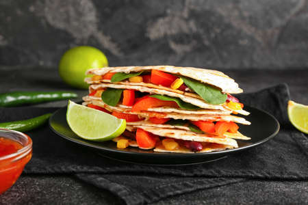 Plate with tasty vegetarian quesadillas on dark backgroundの写真素材