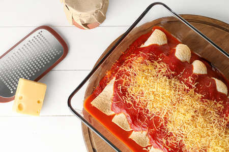 Baking dish with tasty cooked enchilada on tableの写真素材