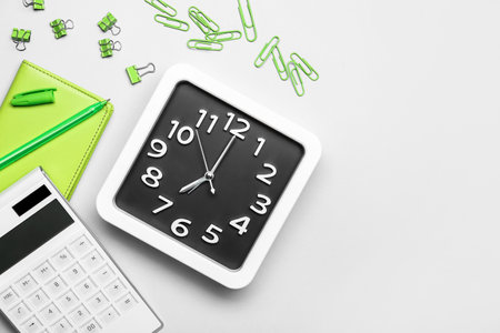 Composition with stylish clock and stationery on light background