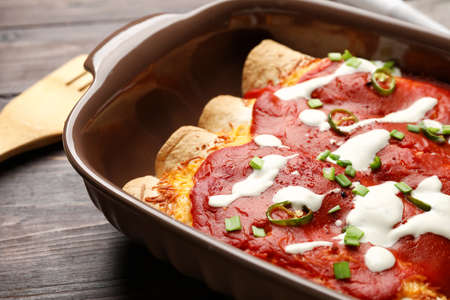 Baking dish with tasty cooked enchilada on table, closeupの写真素材