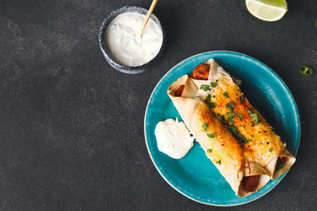 Plate with tasty cooked enchilada on dark backgroundの写真素材