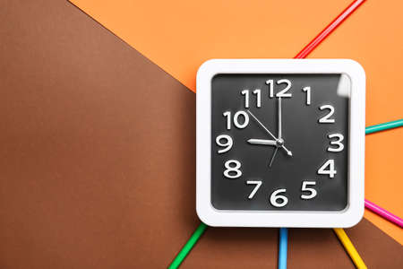 Stylish clock and pencils on color backgroundの写真素材
