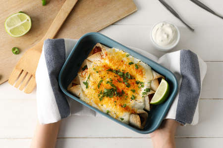 Woman with hot enchilada in baking dishの写真素材