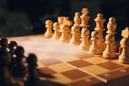 Chess board with pieces on dark background