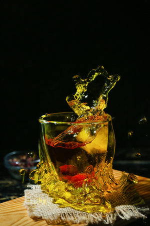 Glass of hot tea with splash on dark backgroundの写真素材