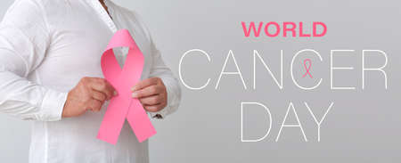 Mature man with pink ribbon on light background. World Cancer Dayの写真素材