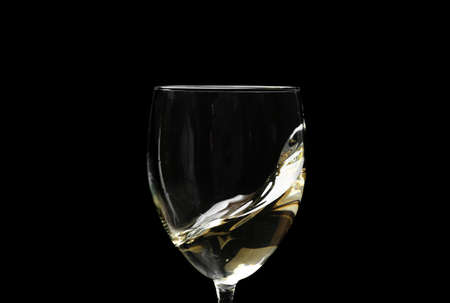 Glass of wine with splash on dark background, closeupの写真素材