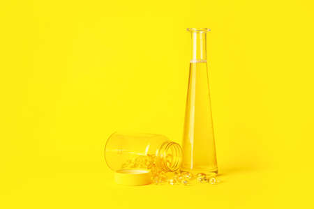 Bottles of fish oil and capsules on color backgroundの写真素材