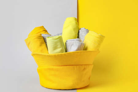 Hat with rolled clean clothes on color backgroundの写真素材