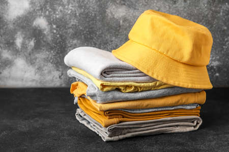 Stack of stylish clothes with hat on grunge backgroundの写真素材