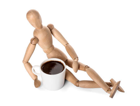 Wooden mannequin with cup of coffee on white backgroundの写真素材