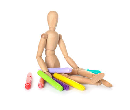 Wooden mannequin with felt-tip pens on white backgroundの写真素材