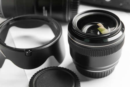 Camera lens and sheet of paper on light background, closeupの写真素材