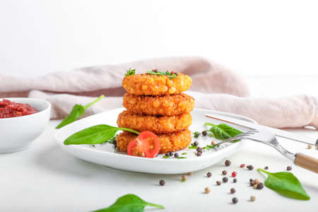 Plate with tasty lentil cutlets on light background