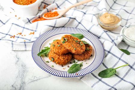 Plate with tasty lentil cutlets on table