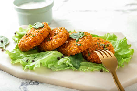 Board with tasty lentil cutlets on tableの写真素材