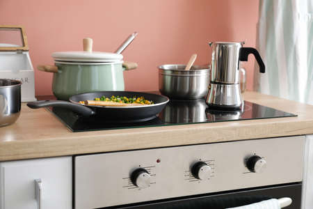Modern electric stove and utensils in kitchen