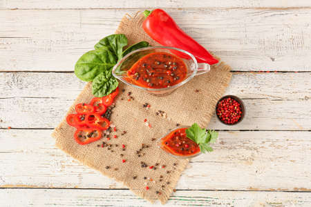 Gravy boats with peppercorn sauce and ingredients on light wooden backgroundの写真素材