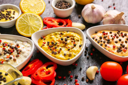Bowls with different sauces and ingredients on dark background, closeupの写真素材